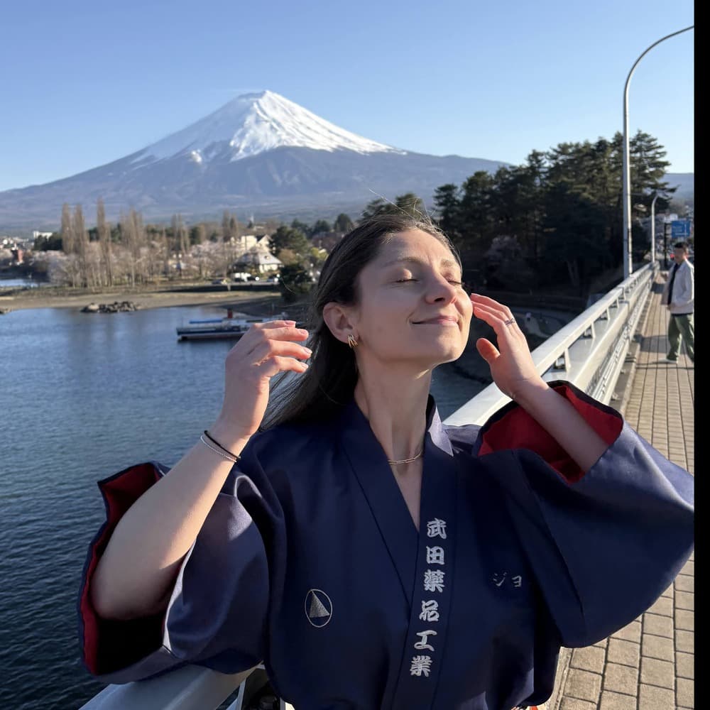 Sam Lapscher by Lake Kawaguchi with Mount Fuji behind her, wearing a navy happi jacket